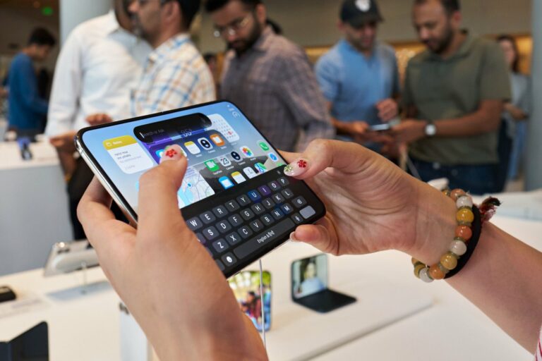A customer’s hands typing on an unfolded iPhone Duo at Apple BKC in Mumbai